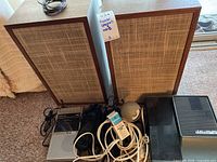 Two wood veneer speakers with cloth grilles, silver portable cassette recorder, black portable cassette recorder, cables and a spherical lamp head