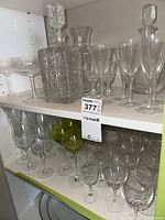 Shelf with clear stemware and square-cut crystal decanter with stopper