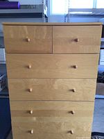 Front view of the 6 drawer dresser showing wood finish, wooden knobs and drawer arrangement