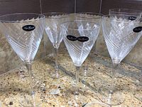 Five clear crystal wine glasses with etched swirl pattern and Luigi Bormioli signature labels. Skinny tall stems and wide bowls etched with swirl.