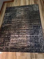 Top view of contemporary area rug showing abstract pattern in blue and gray tones.
