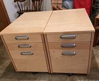 Front view of both cabinets side by side showing drawers, handles, and casters