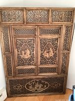 Full front view of the carved wood window panel showing overall design and proportions