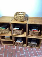 Overall arrangement of wood cubicles in two rows, five baskets, one divided cube and one cube with stacked CDs