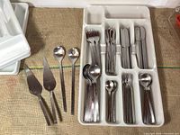White plastic tray organizer loaded with forks, spoons, knives