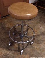 Full view of round tan vinyl seat and chrome base