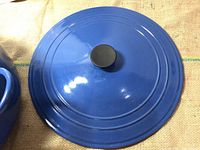 Top view of blue enameled lid with black knob