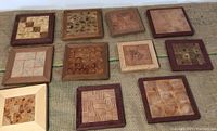 Eleven wood panels arranged to show variety of inlay patterns, woods, and frames