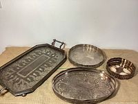 Wide shot of all four silver plated trays on burlap