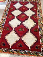 Full view of the Persian rug showing overall geometric lattice and peacock motif design