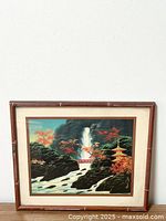 Full view of the framed print showing the entire Japanese landscape scene including waterfall, bridge, pagoda and autumn trees in a bamboo-style frame.