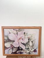 Front view of framed floral print showing a large pink and white flower with green leaves.