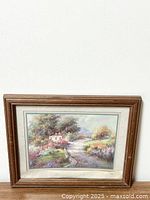 Full view of the framed print showing a cottage in a garden landscape with pathway and surrounding trees and flowers.