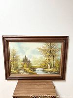 Full view of vintage large oil painting showing forest landscape, river, and trees in brown wooden frame