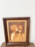 Framed vintage Margaret Kane "A Little Kiss" picture showing a boy kissing a girl on the cheek in a sepia tone with some frame wear.
