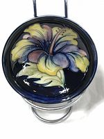 Top view showing the colorful hibiscus flower design inside the bowl with yellow, blue, purple, and pink petals on dark blue background.