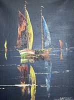 Close-up detail of two sailboats with colorful sails and their water reflection on dark background