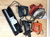 Top-down view of all tools showing the power tools including circular saw, jig saw, sander, and laser level cases.