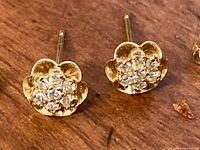 Close-up front view of both earring faces showing floral motif and diamond cluster