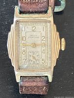 Front close-up of rectangular gold-tone case and cream dial marked Rolex Standard