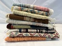Stack of 8 needlepoint squares showing thickness and fabric texture
