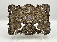 Front view of the carved soapstone plaque on stand showing six mother-of-pearl inlaid medallions and pierced decorative design.