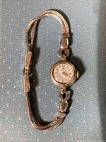 Full view of watch showing case and gold plated bracelet