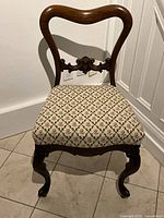 Front view of chair showing balloon‐back frame and needlepoint seat
