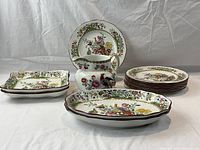 Front view of complete set showing eight round plates, two square platters, two oval platters, and one pitcher with pheasant and floral pattern.