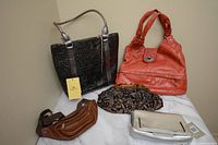 Four bags shown: black embossed handbag with Heather Vest tag, orange leather handbag, brown leather fanny pack, and fabric evening clutch.
