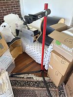 Photo of Feedback Sports bicycle repair stand showing red vertical post with base and clamp arm in a room.