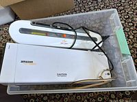 Image showing Amazon Basics laminator with caution hot surface label inside storage container