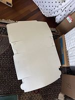 Flat, unassembled large white bakery box showing foldable flaps and tabs