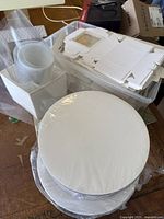 Photo showing stacked round cake boards wrapped in plastic and other baking supply packaging