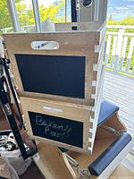 Two stacked wooden crates with natural wood and black chalkboard front panels, showing "Bakery Buns" written in chalk on the lower crate.