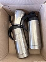 Two stainless steel thermal carafes in a box, one labeled 'CREAM'