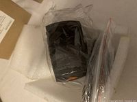 Car camcorder wrapped in plastic inside box with foam padding.