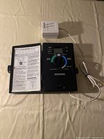 Top view of the Champion irrigation controller showing rotary dial, digital display, and sensor unit with wire.