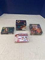 Four boxed collectible card game decks arranged on white cloth background against dark backdrop, showing title and art.