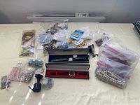 Overview of lot contents showing costume jewelry including bracelets, necklaces, and watches in boxes