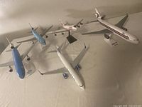 Lot showing all 5 collectible scale model airplanes on a flat surface from overhead view.