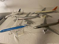 Photo showing all 5 airline model airplanes displayed with distinct airline colors and logos on stands.