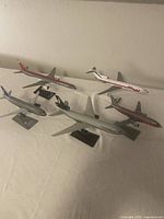 Five scale model airplanes on stands showing different airline liveries including Western, Caledonian, Northwest, and United.