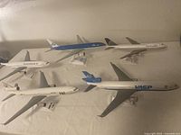Lot of 5 vintage scale model airplanes from various international airlines on stands.