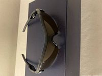 Oakley sunglasses resting on a dark surface, showing the lens curve and lightweight frame design.