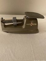 Side angle showing the full manual postal scale with sliding weight indicator and weighing platform.