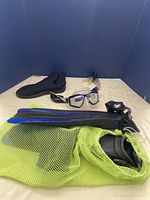Full snorkeling gear set including mask, fins, snorkel, boots, and mesh storage bag.