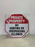 Front of a sealed aluminum No Trespassing sign with red and white colors and clear text.