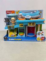 Front view of the Fisher-Price Little People airplane playset in original packaging with two figures on display and airplane on top of terminal building.