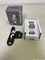 Garmin Lily 2 smartwatch in packaging with charging cable and original box